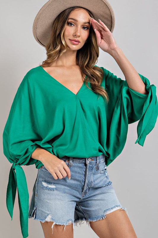 Green long sleeved blouse which has ties on the cuffs and a v neck, size small to large.