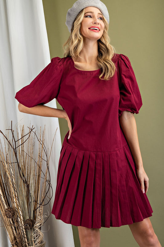 Dress in wine color, above the knees, puff sleeves and pleats.  Size small to large.