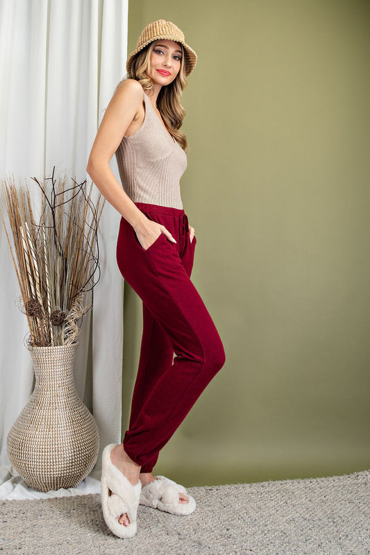Wine colored jogger pants with pockets and elastic cuffs.