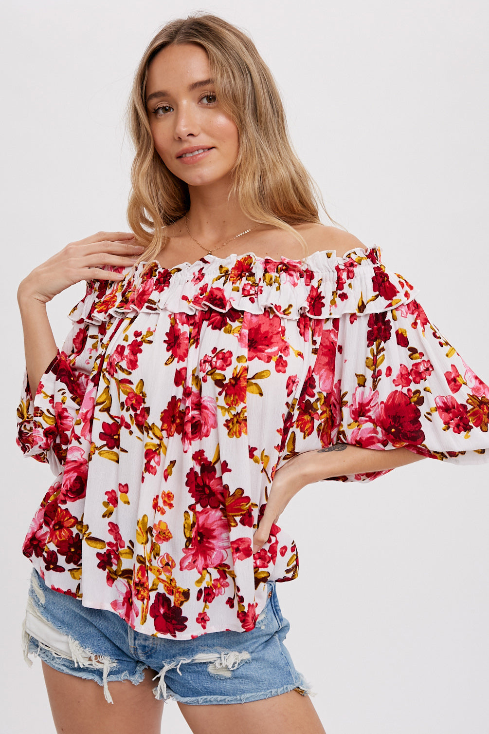 White floral blouse with elasticized ruffle neckline, size small to large.