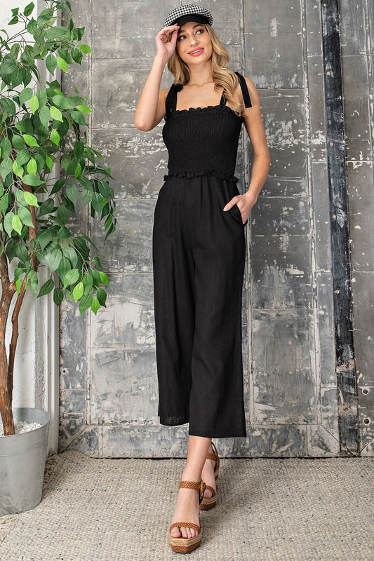 Smocked black jumpsuit with straps, ruffles and pockets, size small to large.